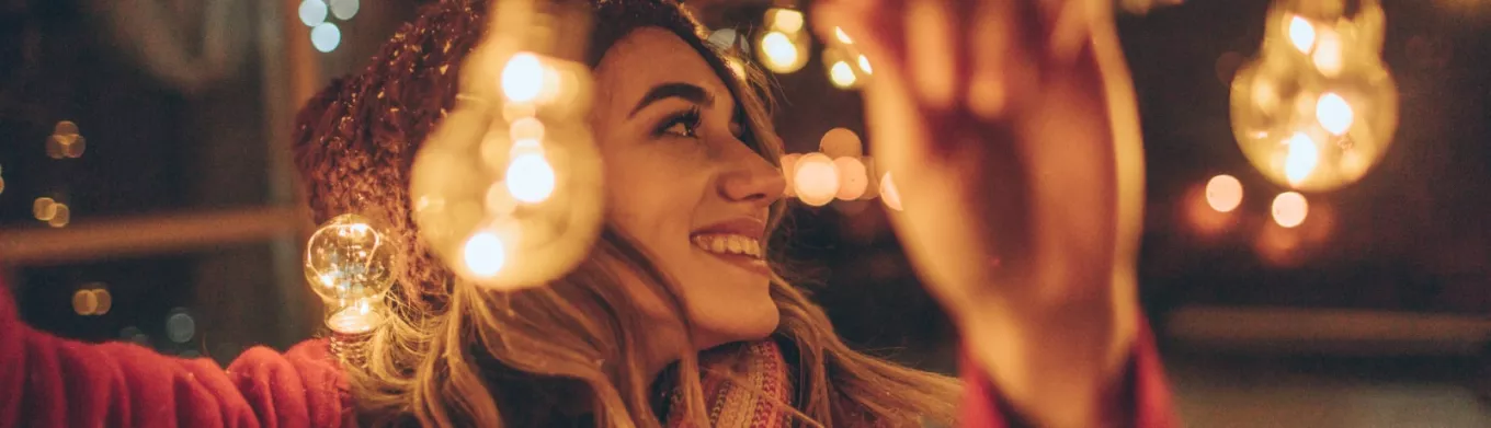 Jeune fille accrochant des guirlandes de Noël